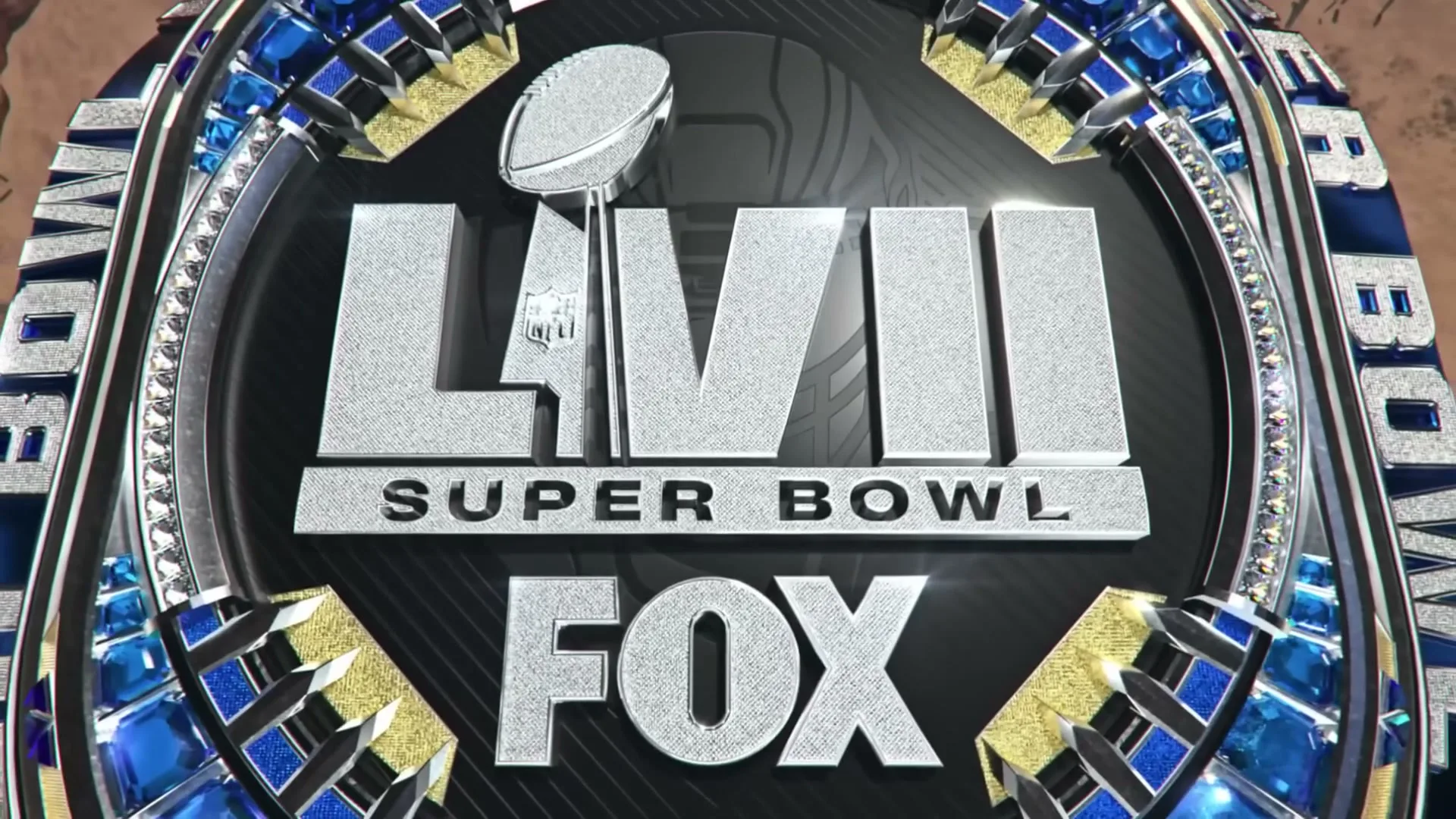 A close-up shot of the Super Bowl LVII logo, which is metallic and adorned with blue and gold accents, before it transforms into a textured tunnel.