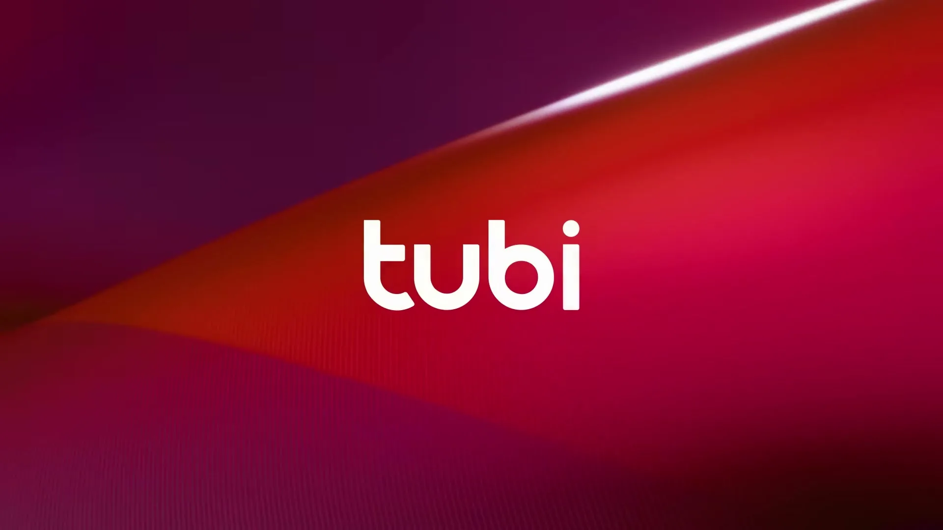 The Tubi logo is displayed prominently in white against a dynamic, abstract background of shifting red and purple hues, with a bright diagonal light streak.