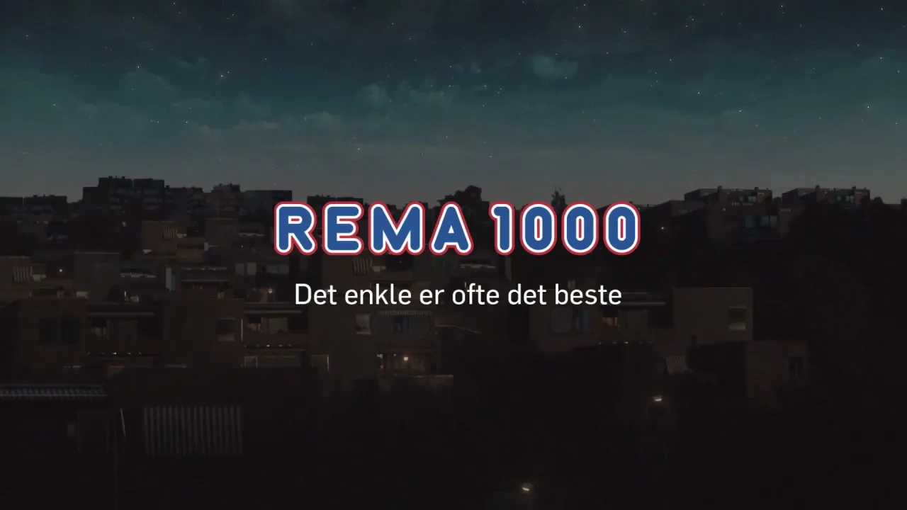 An aerial wide shot of a city at night, with the REMA 1000 logo and tagline appearing on screen.