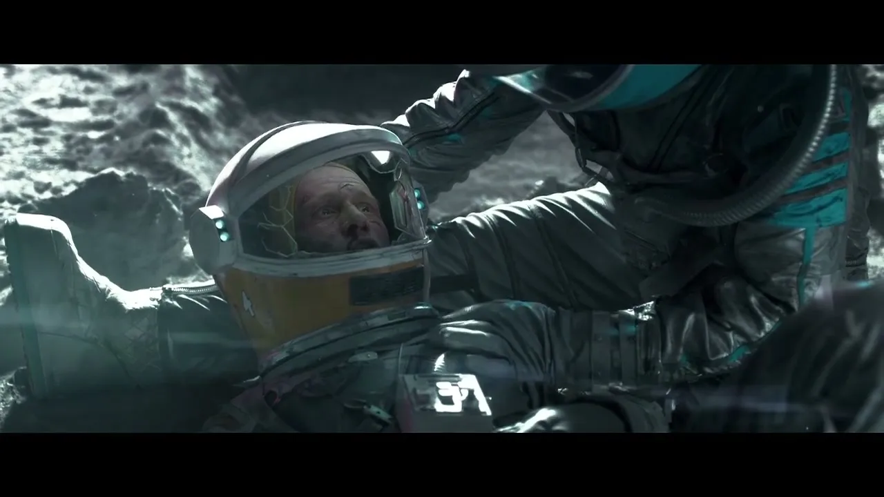 Two astronauts in space suits are on a rocky, cratered surface, one tending to the other who appears injured or dying.