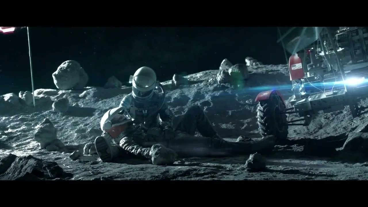 Two astronauts in white suits are on the moon, one kneeling over the other who is lying on the ground, with a lunar rover nearby.