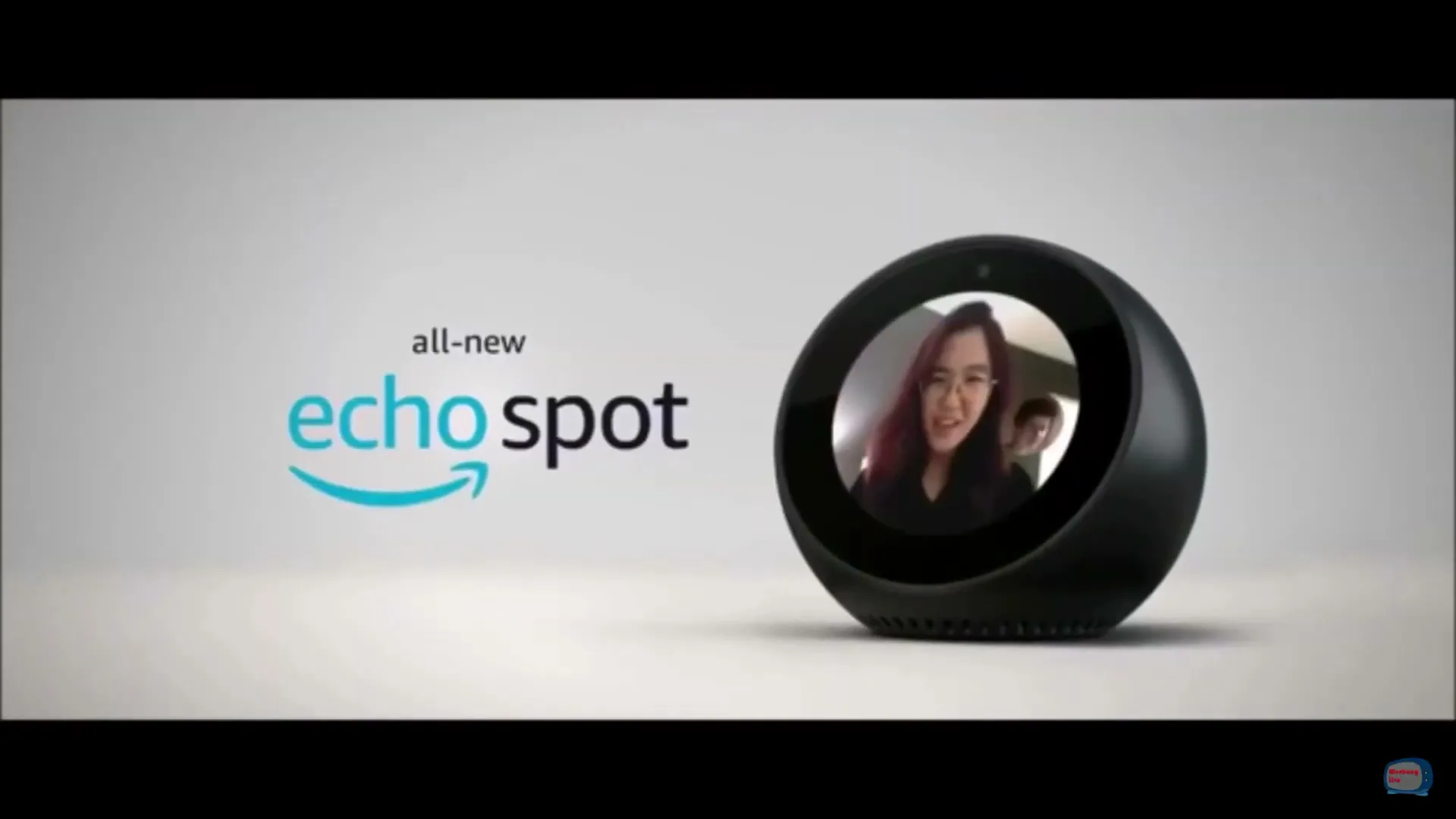 The all-new Echo Spot is displayed on a white surface, showing a video call with a woman and a man on its screen.