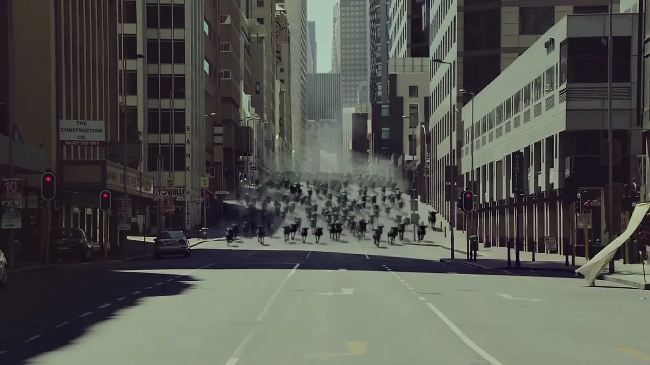 A wide shot of a city street shows a stampede of blurred, dark figures running towards the camera, creating a sense of urgency.