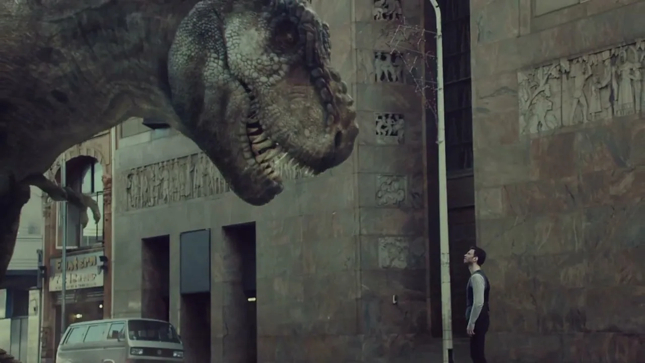 A man in a vest looks up at a giant T-Rex in a city street, with a van parked nearby.