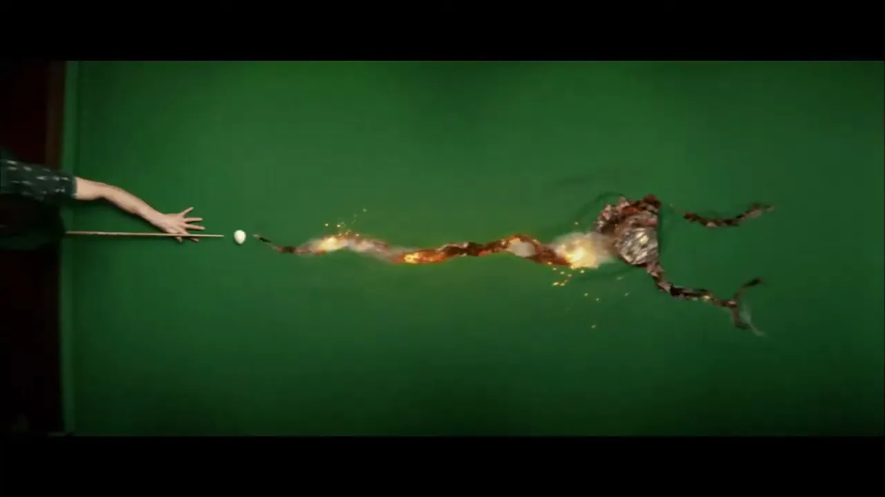 A man in a patterned shirt plays pool, as the cue ball hits a second ball, causing a fiery, explosive reaction across the green felt.
