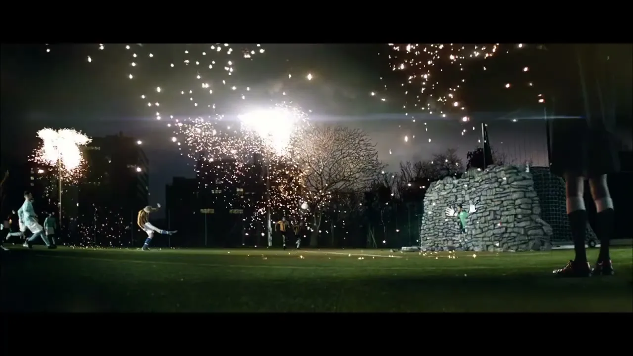 A soccer player in a yellow jersey kicks a ball on a field at night, surrounded by fireworks and other players.