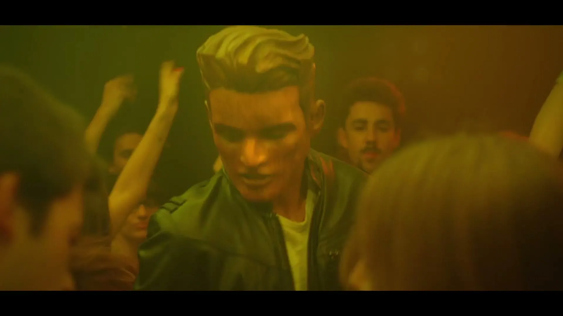 A young man with sculpted hair and a leather jacket dances in a crowded, dimly lit nightclub, surrounded by other partygoers.