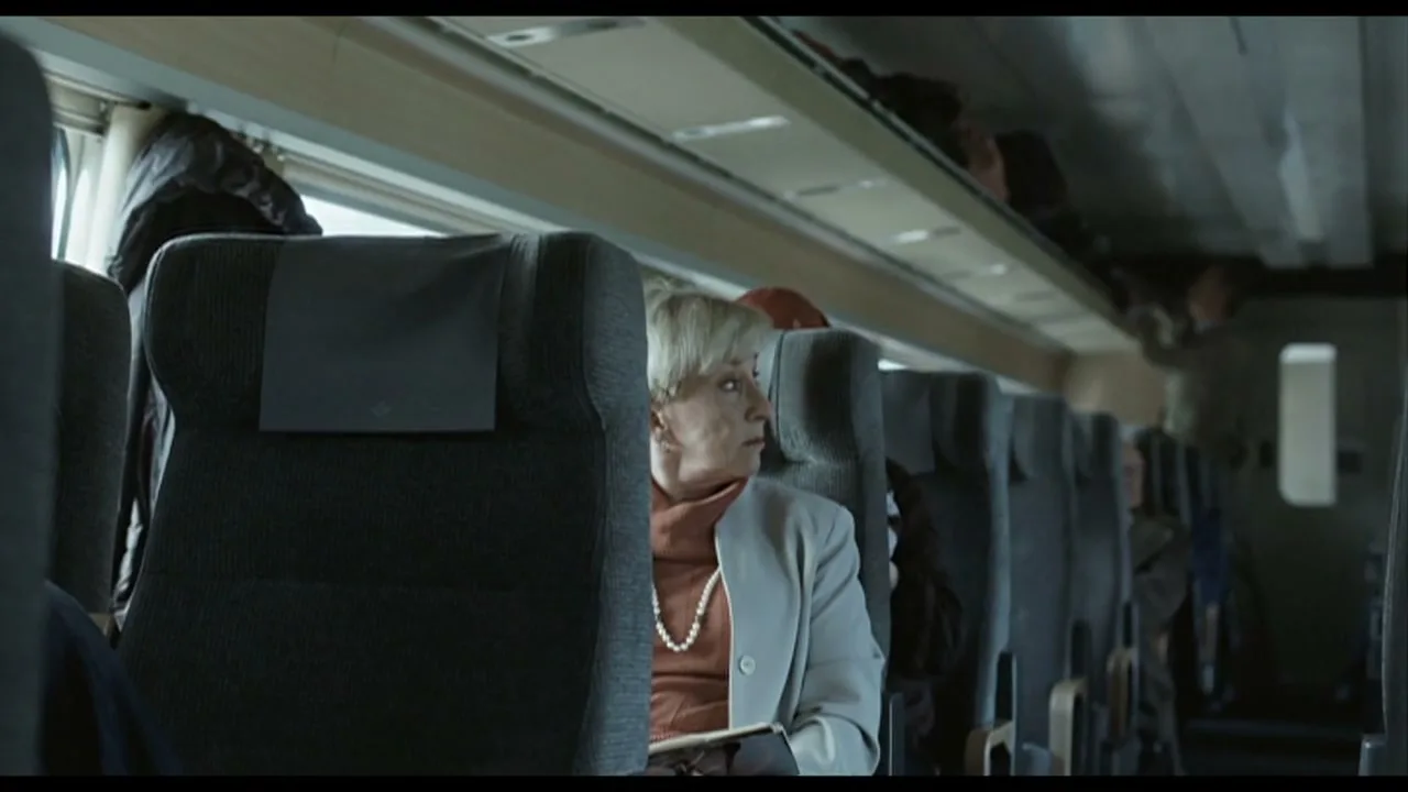 A young boy in a red cap and striped shirt peeks over the seat, smiling, while an older woman in a pearl necklace reads a book on a train.