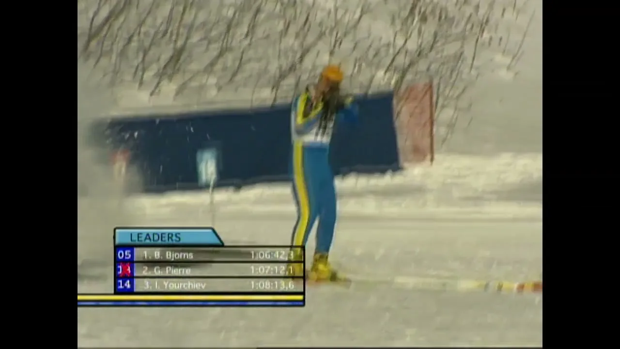 A male biathlete in a blue and yellow suit stands on skis, aiming a rifle at a target in a snowy outdoor setting during a competition.