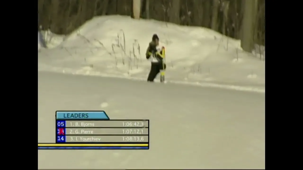 A male biathlete in a blue and yellow suit shoots a rifle at a target in a snowy, wooded area during a competition.