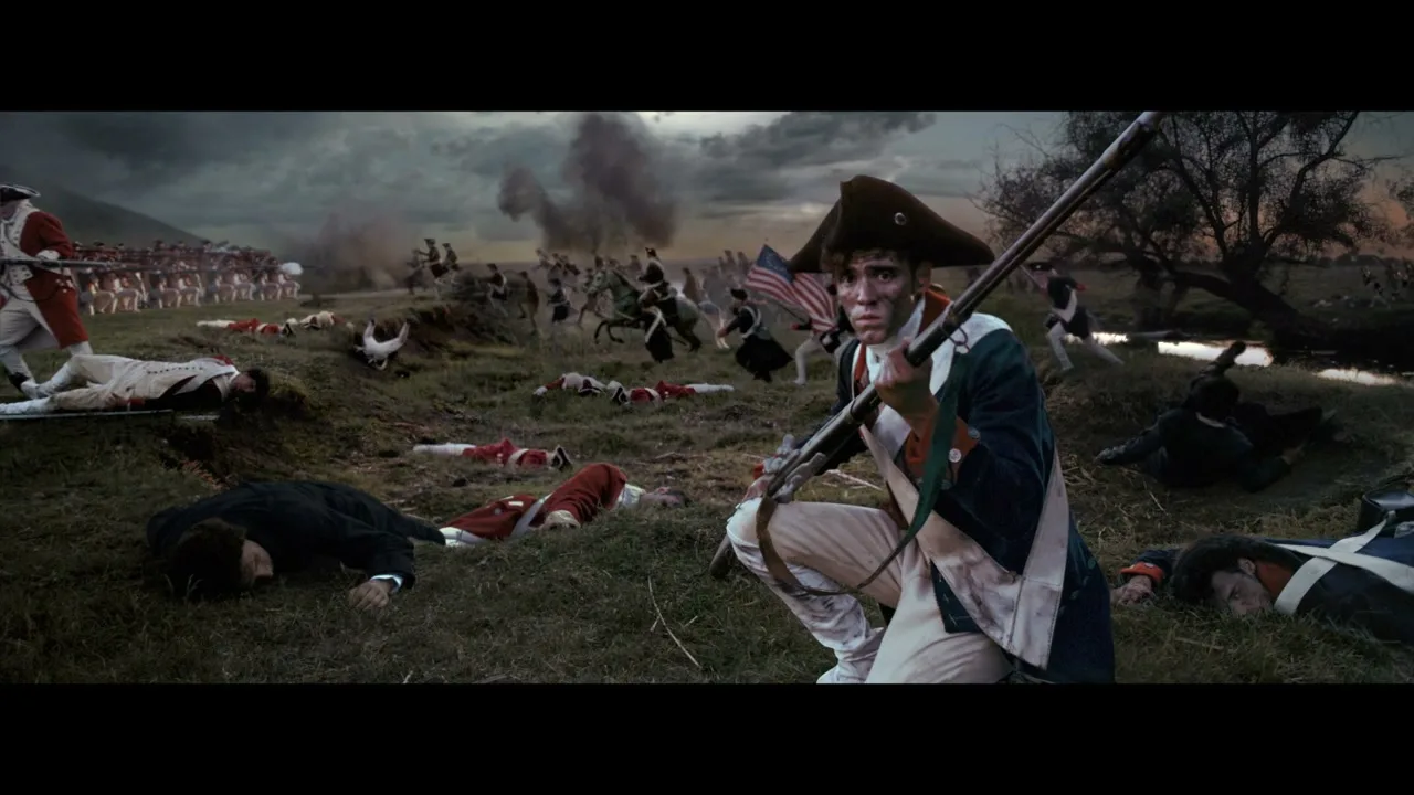 A young male soldier in colonial uniform kneels on a battlefield, holding a rifle, with dead soldiers and a distant battle raging behind him under a stormy sky.