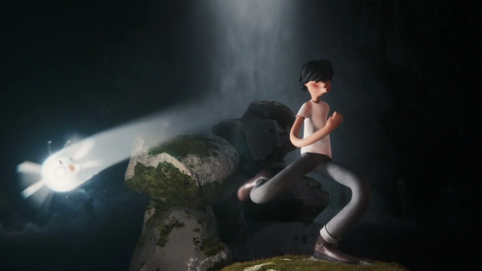 A stylized animated boy with dark hair and a white t-shirt stands on a mossy rock, looking at a glowing white creature in a dark, misty cave.