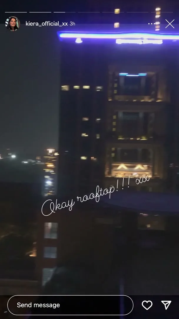 A phone screen shows a user's story with a night view of a city skyline and buildings, with text overlayed on the image.