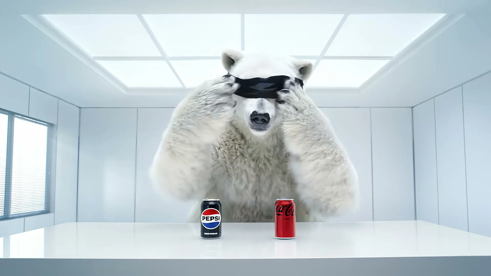 A blindfolded polar bear sits at a white table, tasting a Pepsi Zero Sugar and a Coca-Cola Zero Sugar, then removes the blindfold.