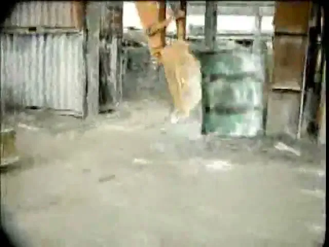 A wide shot shows an excavator bucket swinging into view in a dirty, industrial-looking interior space.