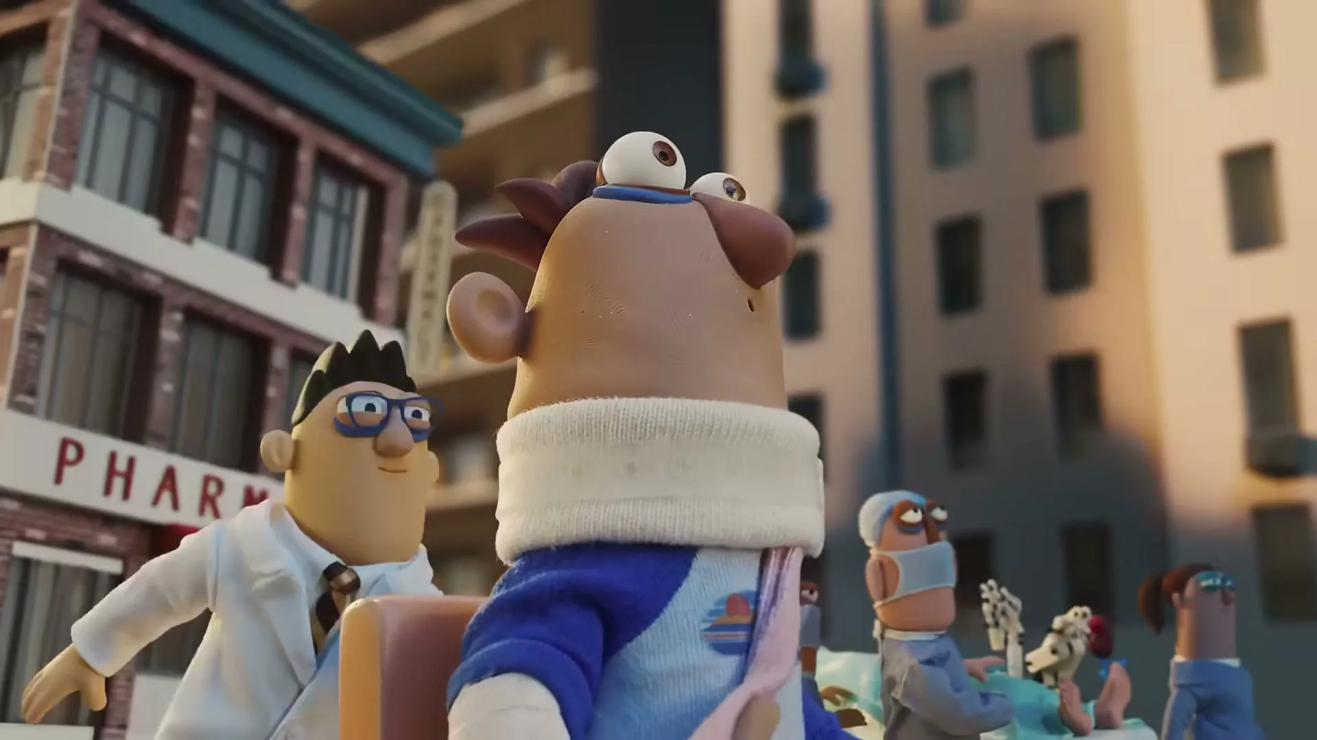 A claymation patient with a neck brace and arm cast looks up as a pharmacy building moves past in a city.
