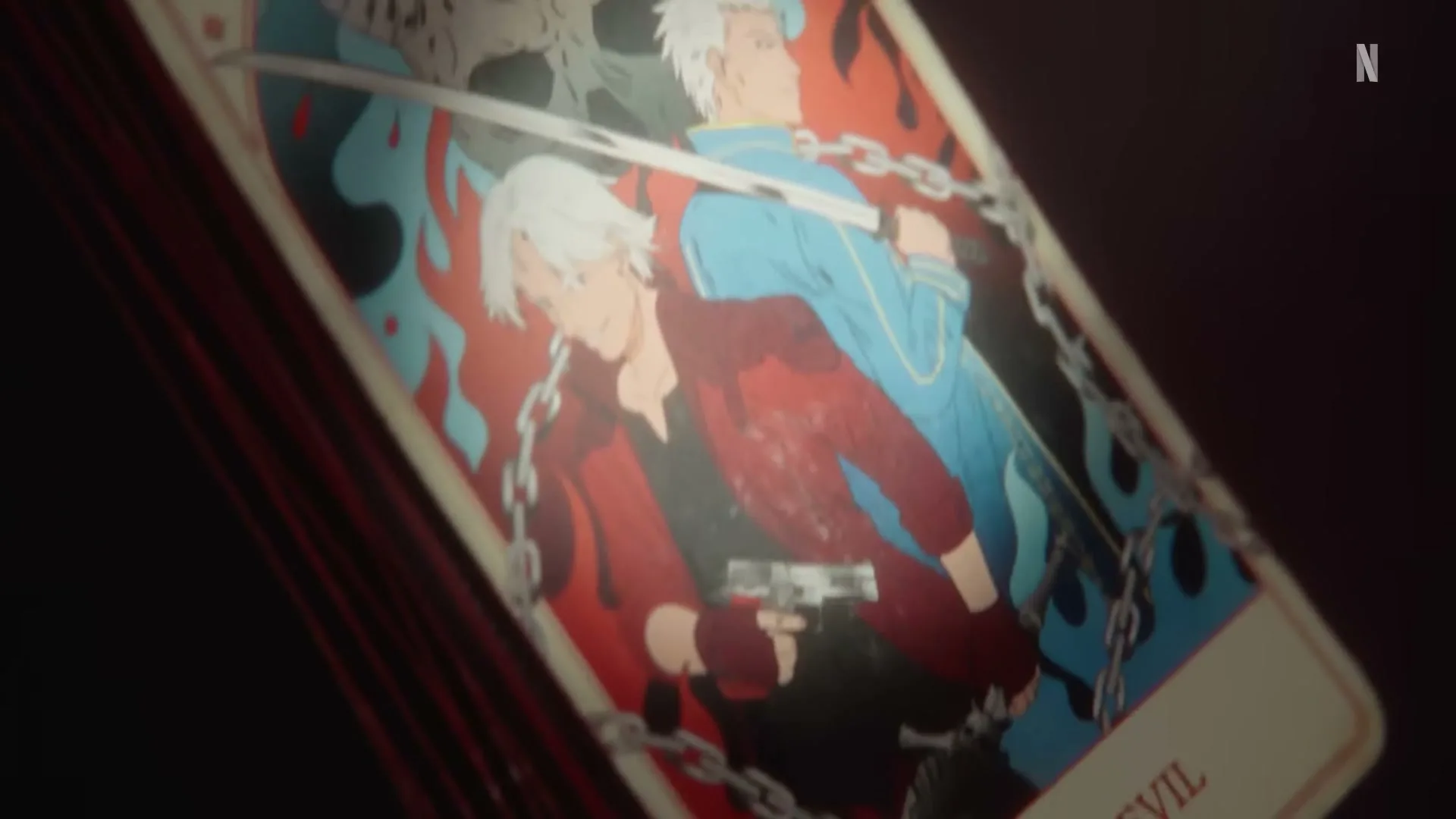 A tarot card featuring two animated male characters, one in red holding a gun and the other in blue with a sword, is shown on a dark surface.