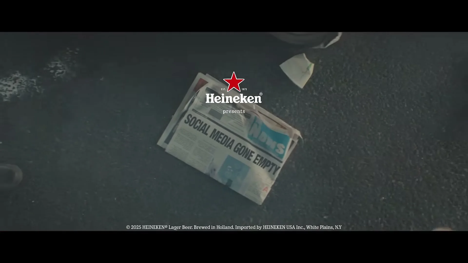 A newspaper with the headline "SOCIAL MEDIA GONE EMPTY" lies on a dark, wet ground, with the Heineken logo and "presents" superimposed above it.