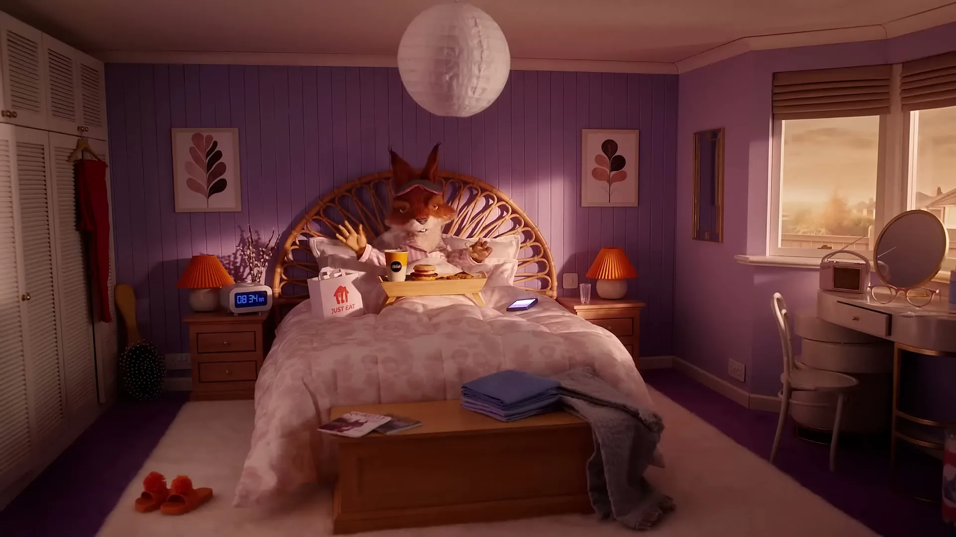 A fox-like creature with large ears and a fluffy tail sits up in bed, enjoying breakfast on a tray in a cozy, purple bedroom.
