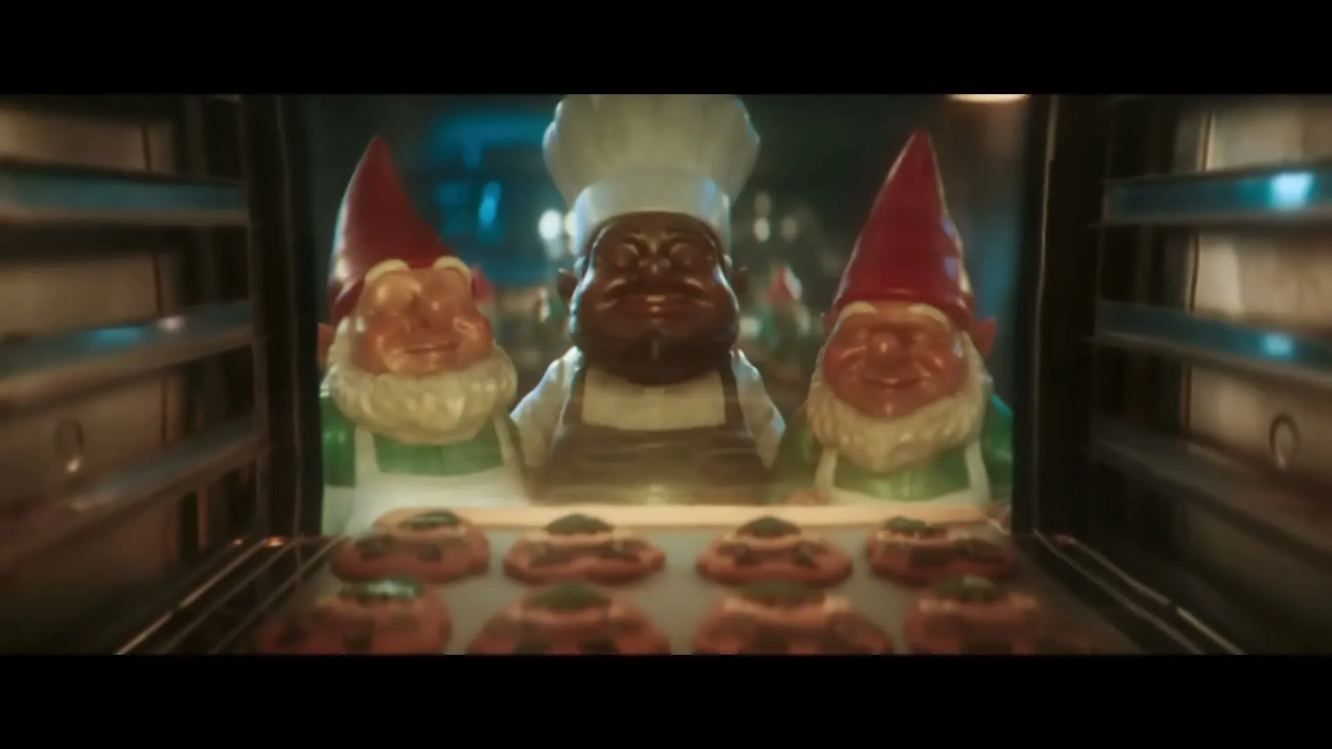 Three garden gnomes, one dressed as a chef, smile from inside an oven, with a tray of cookies in the foreground.