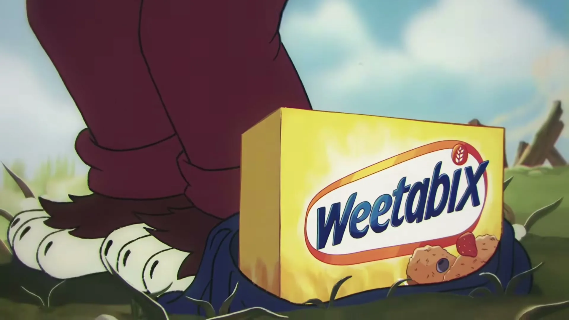 A cartoon wolf's foot is shown next to a box of Weetabix cereal on a grassy hill under a blue sky.