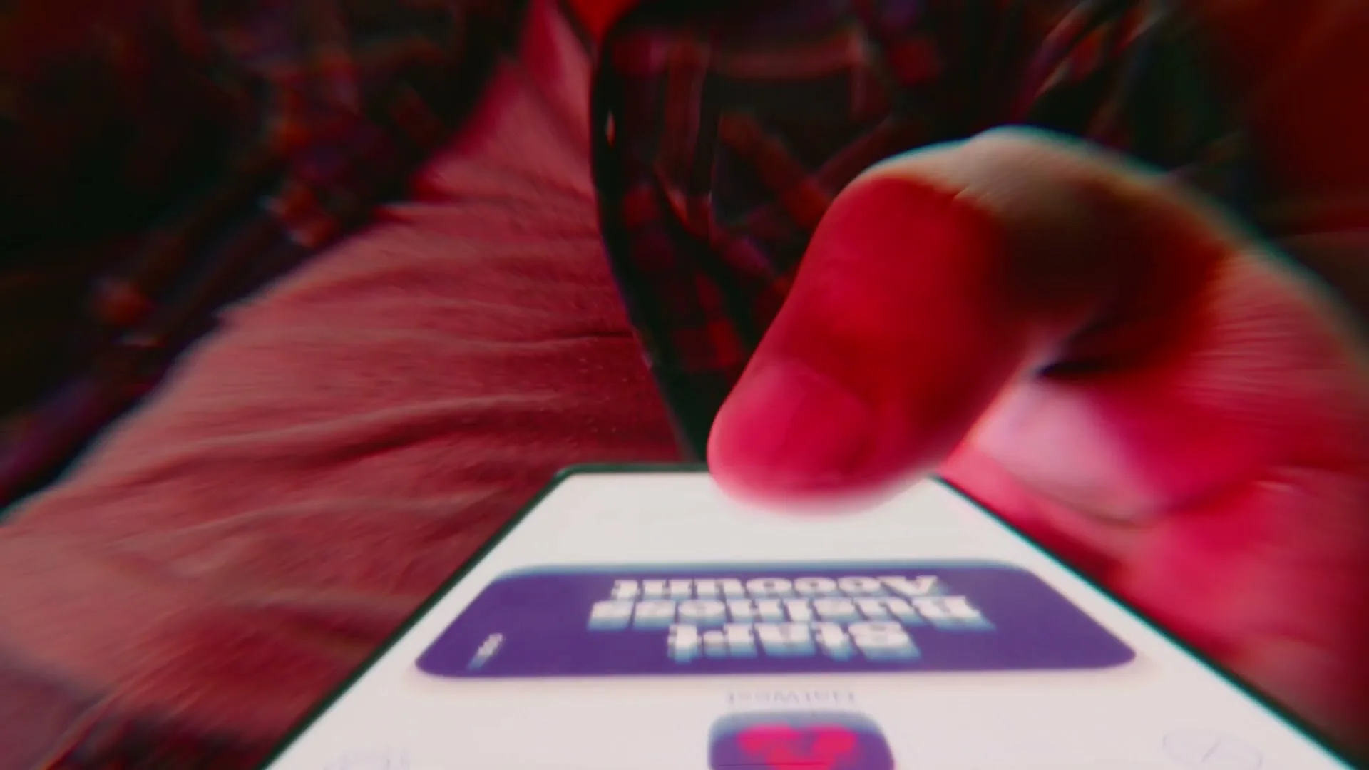 A person's hand taps on a smartphone screen, displaying an upside-down NatWest app interface, in a close-up shot.