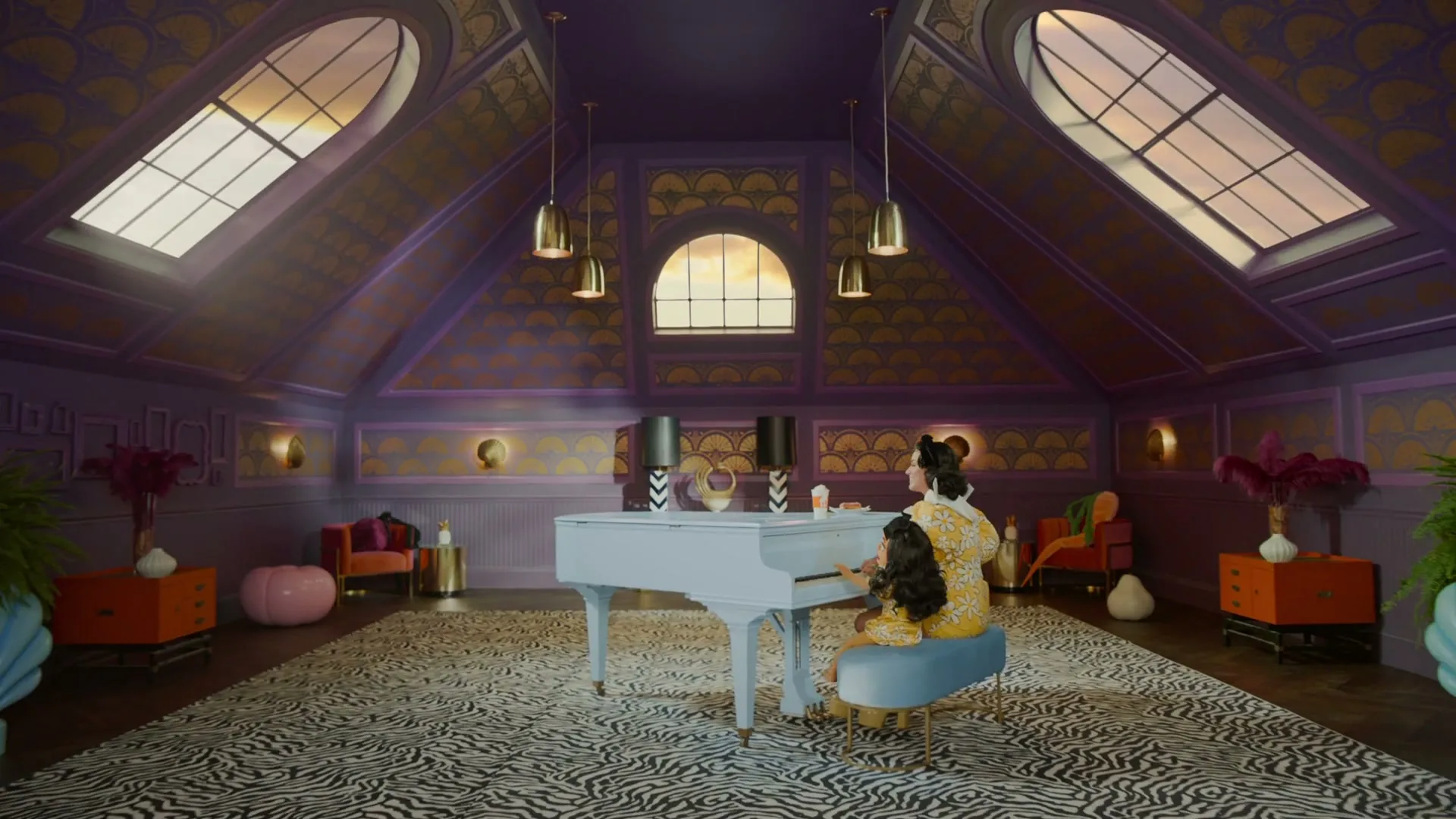 Katy Perry and a child sit at a white piano in a lavish, purple and gold attic room, with food containers on the piano.