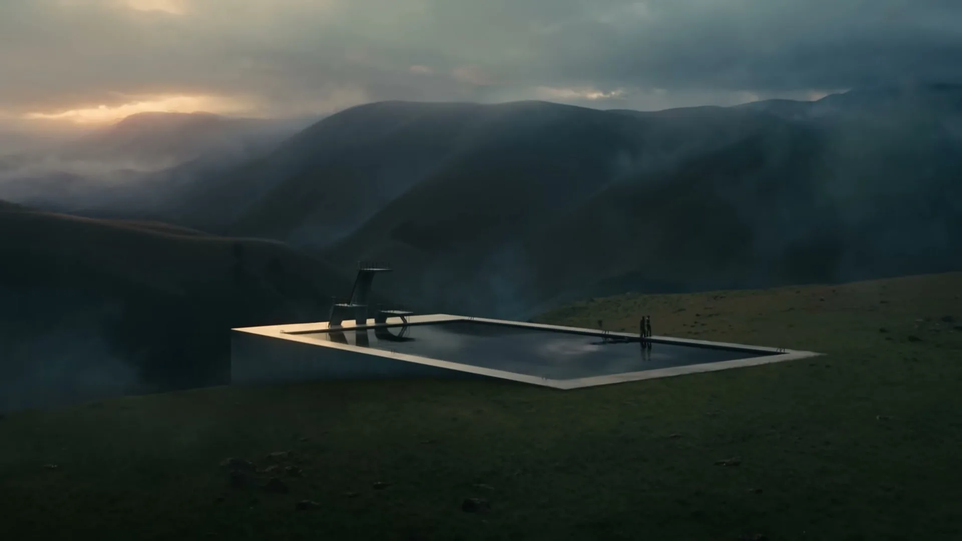 An Olympic-sized pool of oil sits on a grassy hill overlooking misty mountains at dusk, with two figures standing by the pool.