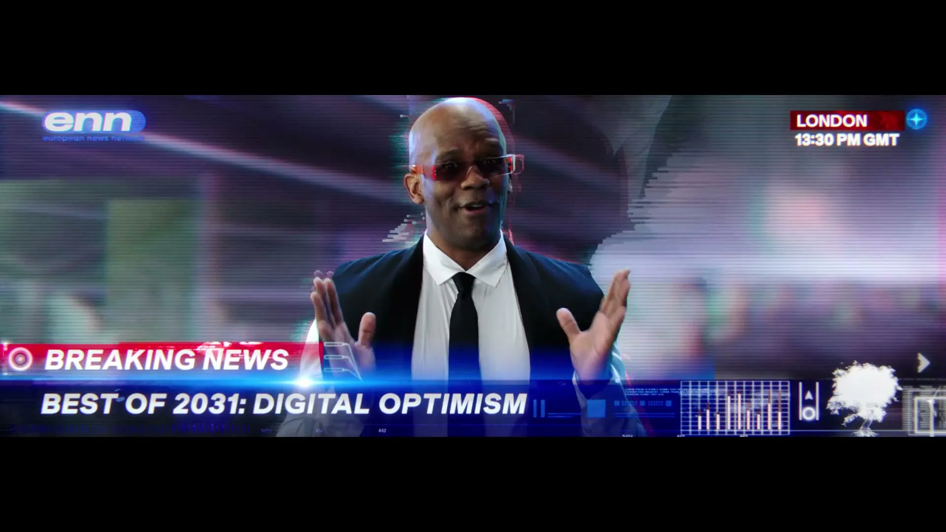 A bald Black man in a suit and red glasses gestures while reporting news in a futuristic virtual studio with "BREAKING NEWS" and "BEST OF 2031: DIGITAL OPTIMISM" on screen.