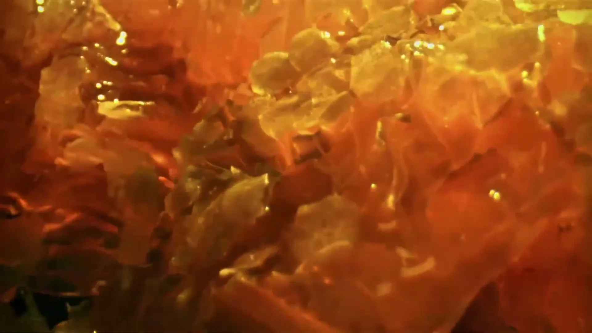 A close-up shot of golden honeycomb with glistening honey, filling the frame with its natural, textured beauty.