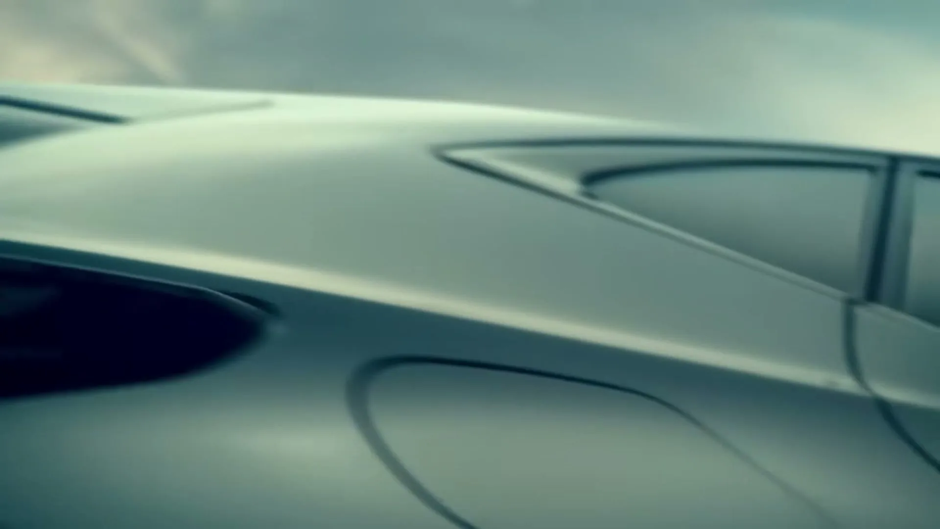 A close-up shot of a silver Lexus car, with its sleek design and reflective surface, against a cloudy sky.