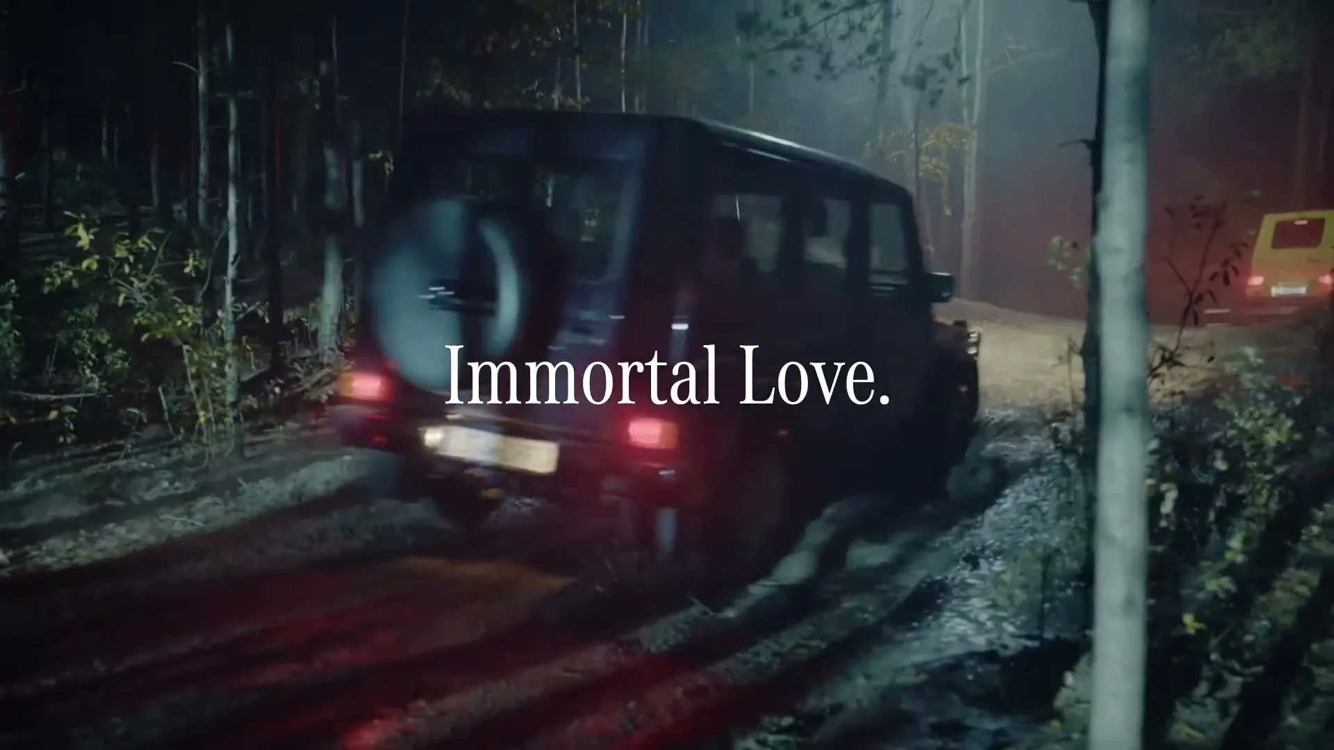 A dark Mercedes G-Wagen drives through a muddy forest road at night, with "Immortal Love." text overlaid.