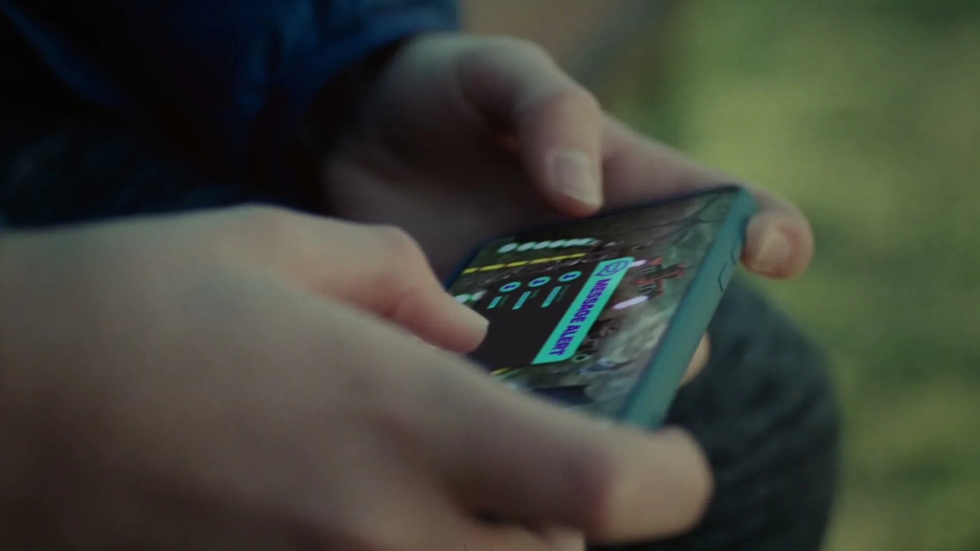 A person's hands hold a smartphone displaying a "MESSAGE ALERT" on a map, as they tap the screen outdoors.