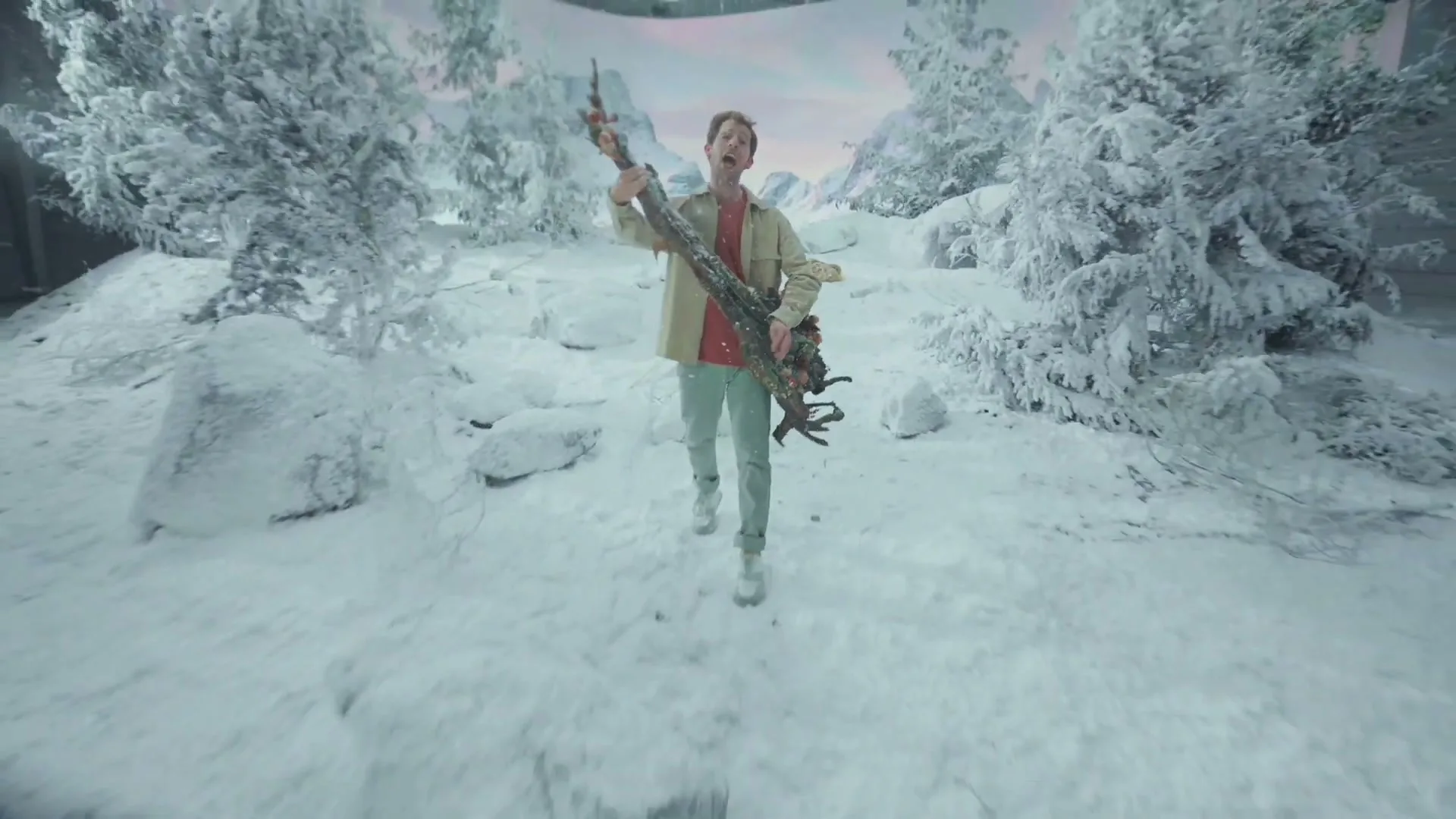 A man in his 30s, dressed in a beige jacket and red shirt, plays a tree branch like a guitar in a snowy, artificial winter wonderland set.