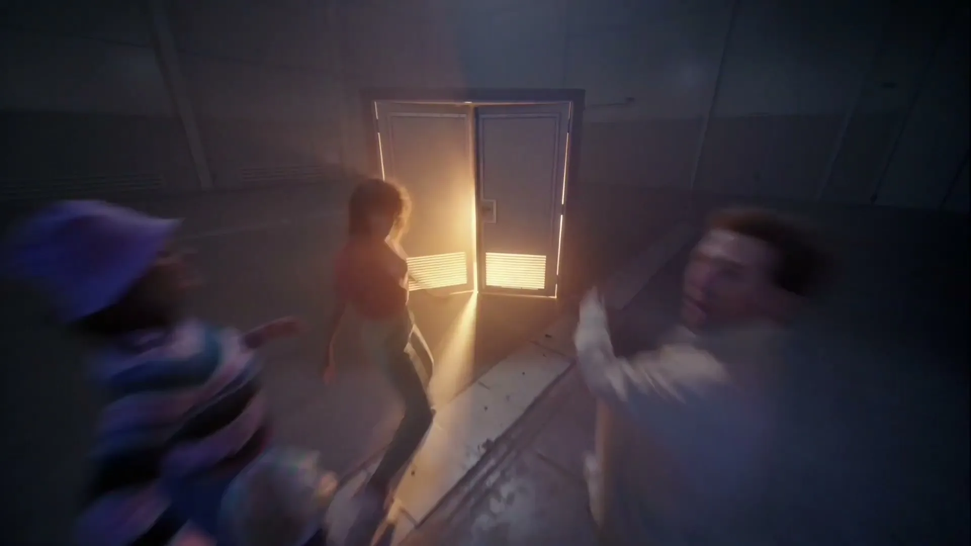 A group of diverse people, dressed in casual attire, walk towards a bright light emanating from an open door in a dark, industrial-looking room.