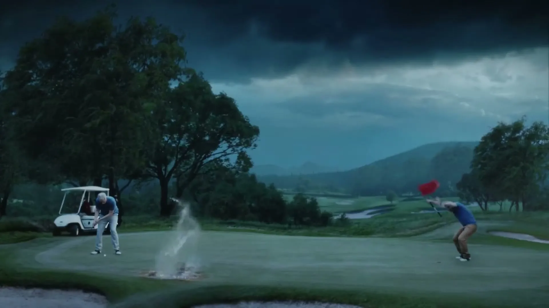 Two men are playing golf on a green under a stormy sky, and one man misses a putt, causing a splash of water from the hole.