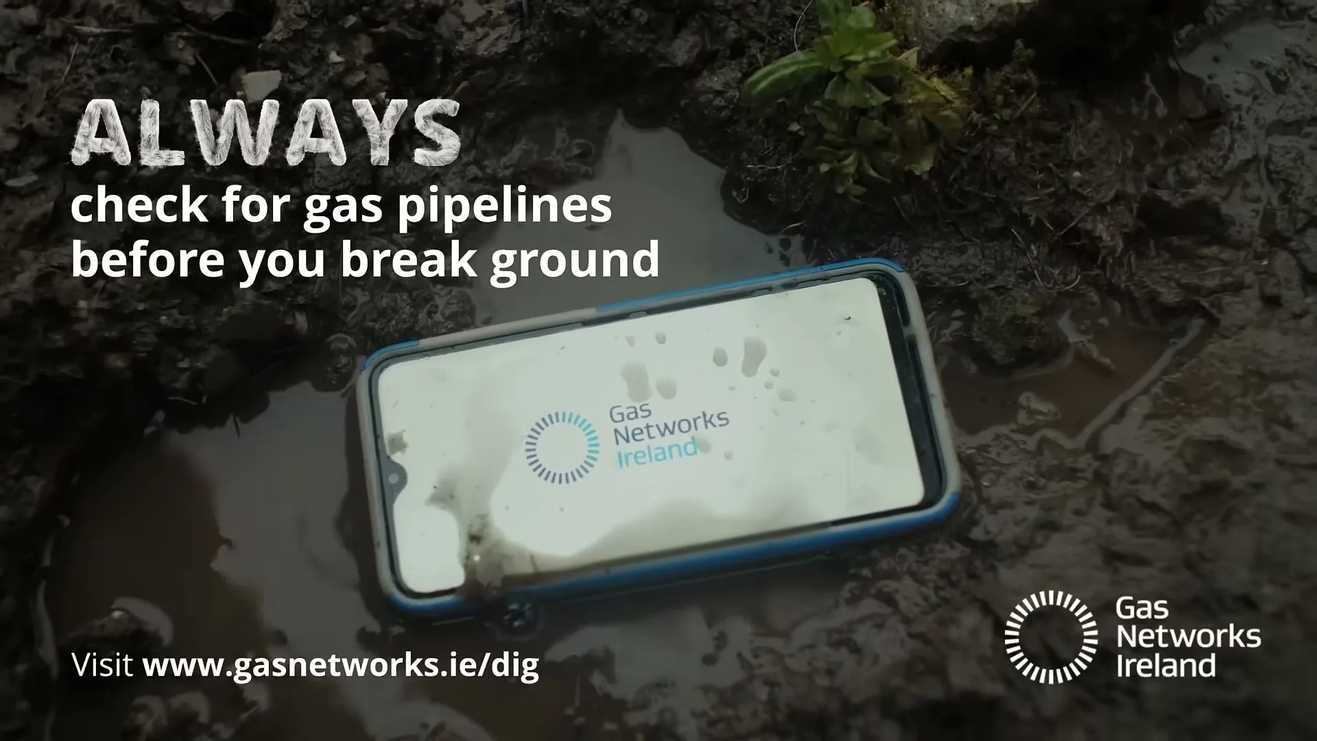 A smartphone with the Gas Networks Ireland logo on its screen lies in a muddy puddle, with text overlayed on the shot.