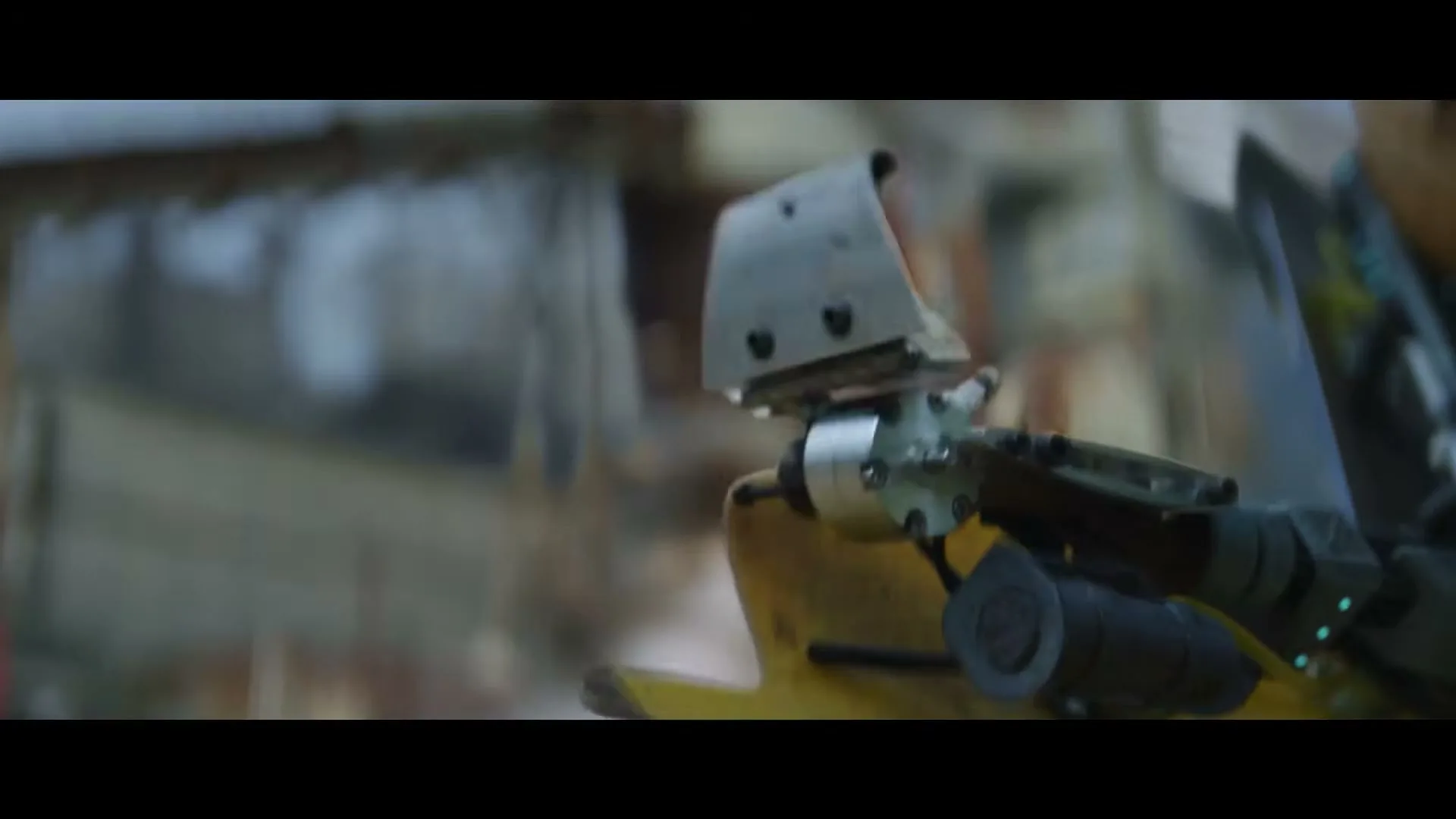 A close-up of a person's prosthetic arm, made from recycled materials, moving slightly in an outdoor setting.