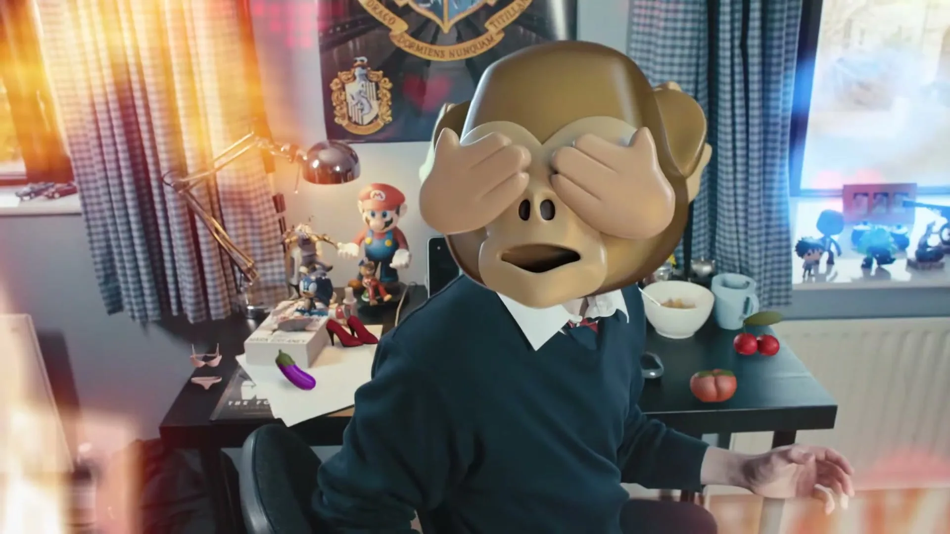 A person with a monkey emoji head covering its eyes sits at a desk in a bedroom, surrounded by various objects.