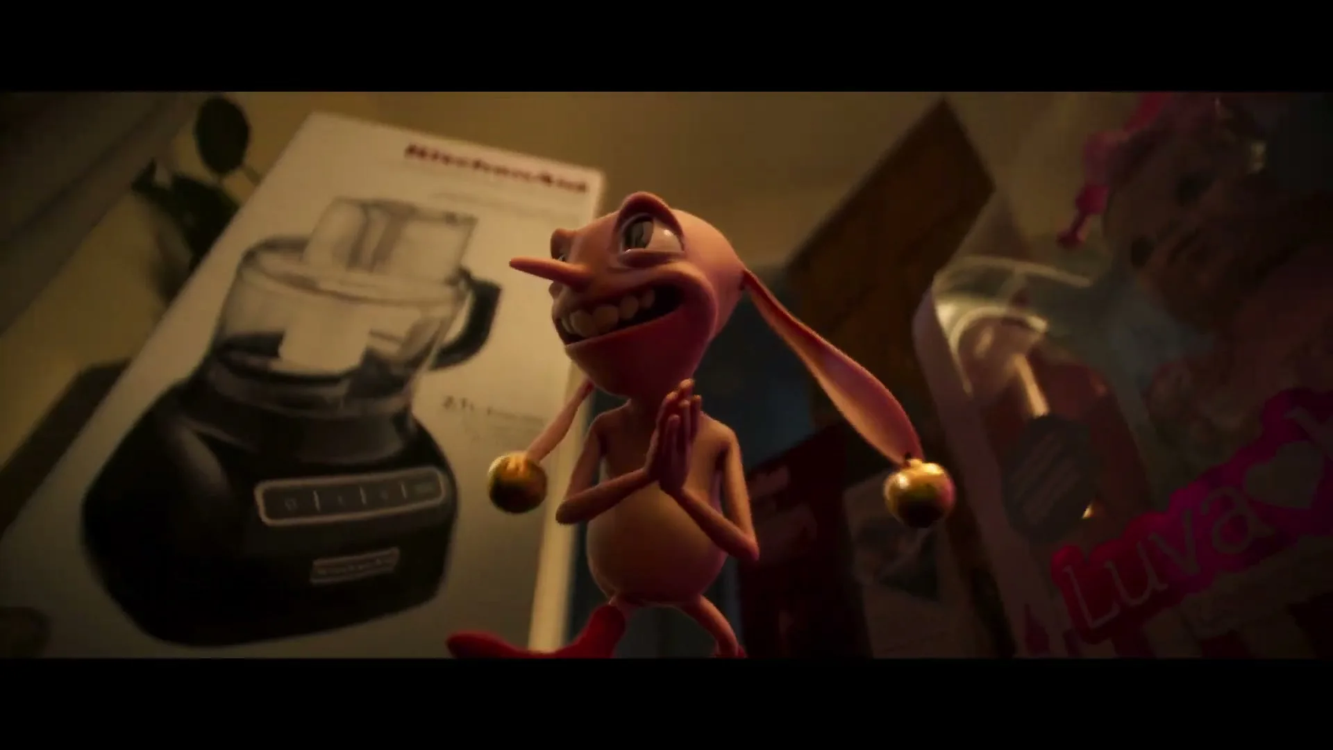 A mischievous pink animated creature with bells on its ears stands surrounded by gift boxes, rubbing its hands together with a wide grin.