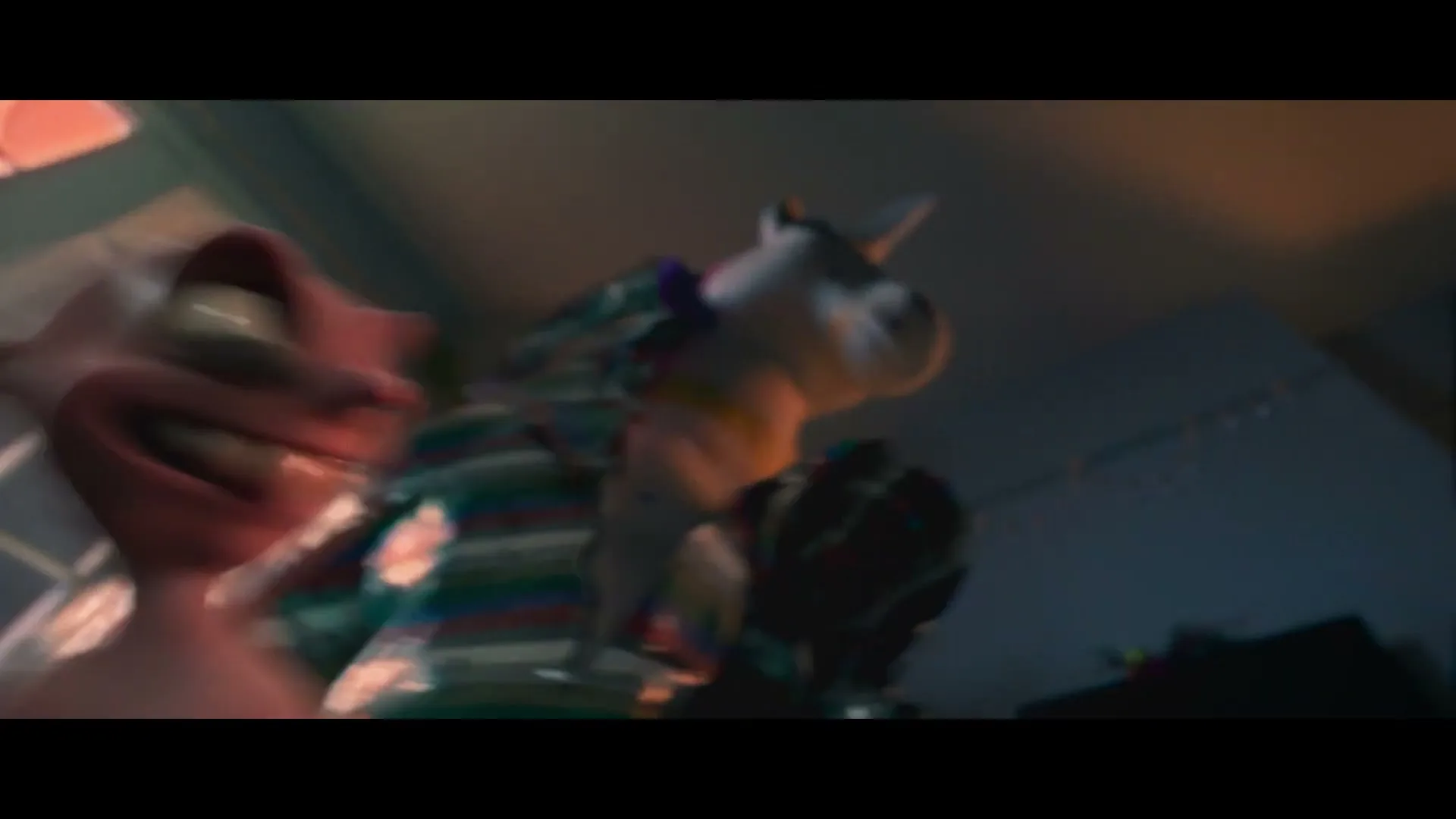 A small pink creature with big eyes and a wide smile jumps on a large, striped unicorn toy in a dimly lit room, while two people enter through a doorway.