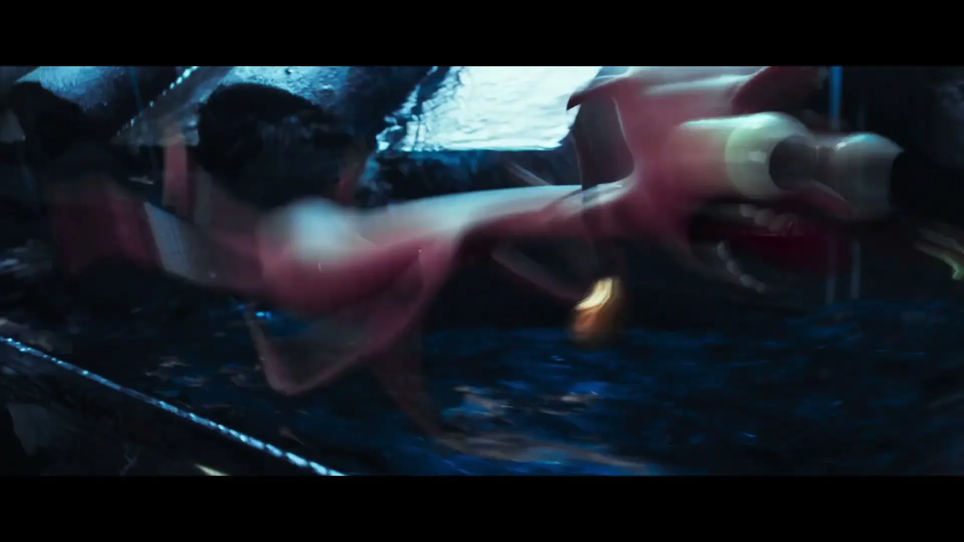 A small, pink, goblin-like creature with large eyes and a wide, toothy grin, wearing a small bell, is seen in a dark, watery environment, flailing its arms and falling.
