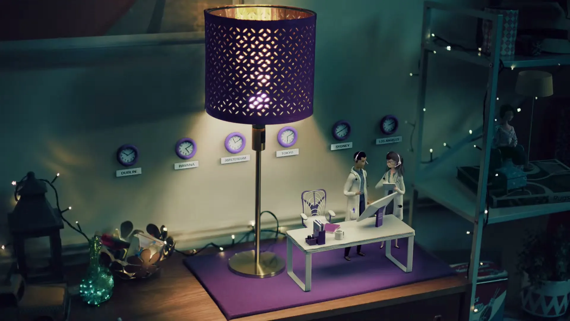 A woman's hand adjusts a purple lamp next to a miniature office scene with two figures and multiple clocks on the wall.