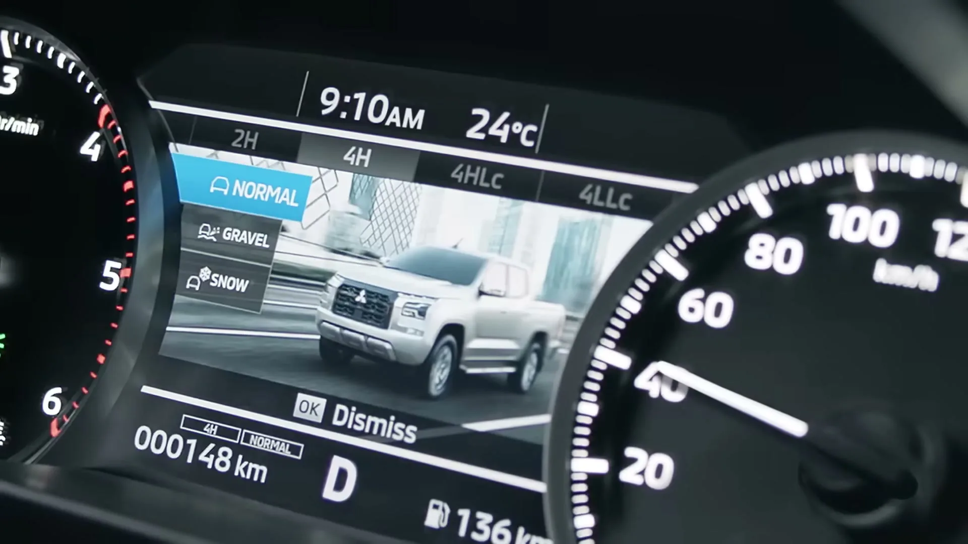 A close-up shot of a Mitsubishi Triton's digital dashboard, displaying driving modes and a graphic of the truck.