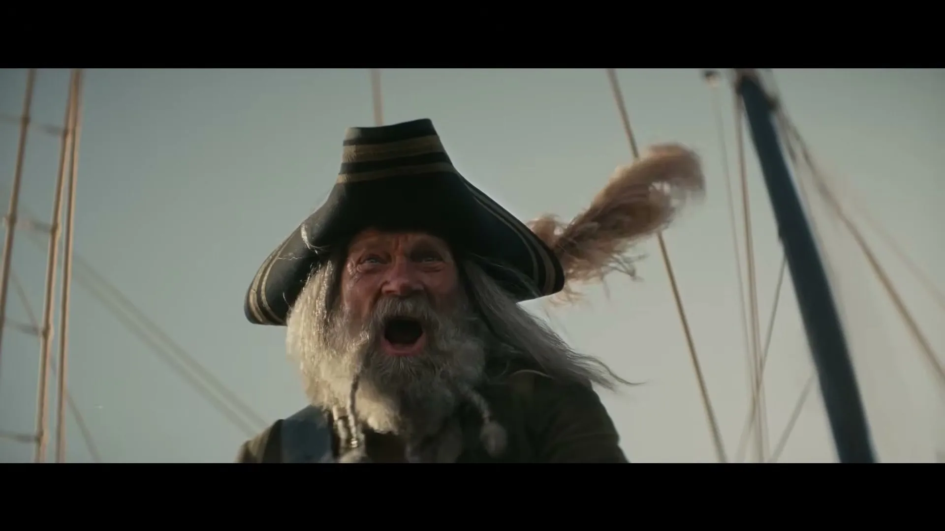 A grizzled old pirate with a long white beard and a feathered hat screams in terror on a ship's deck under a bright sky.