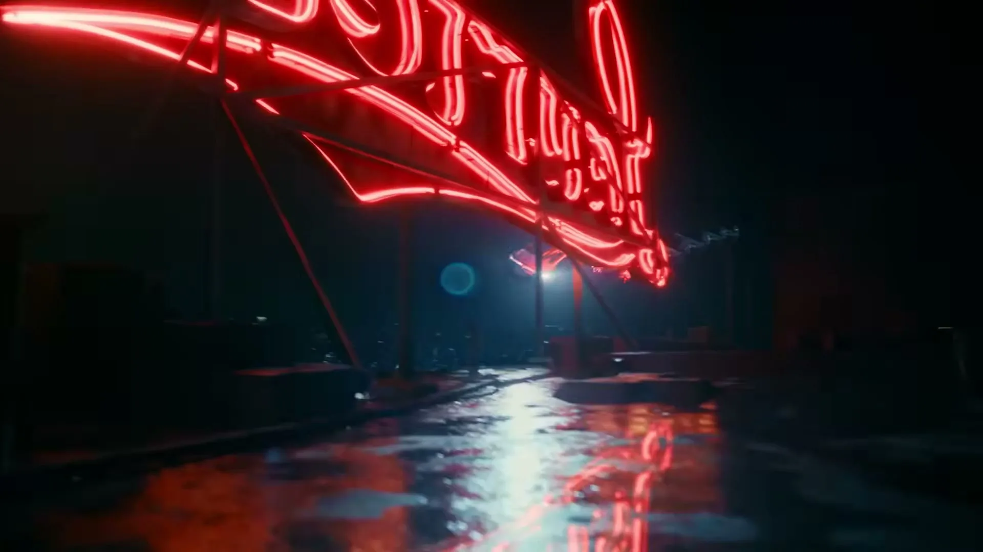 A large, bright red neon sign with illegible text is reflected on a wet, dark surface at night, with cars speeding past in the background.