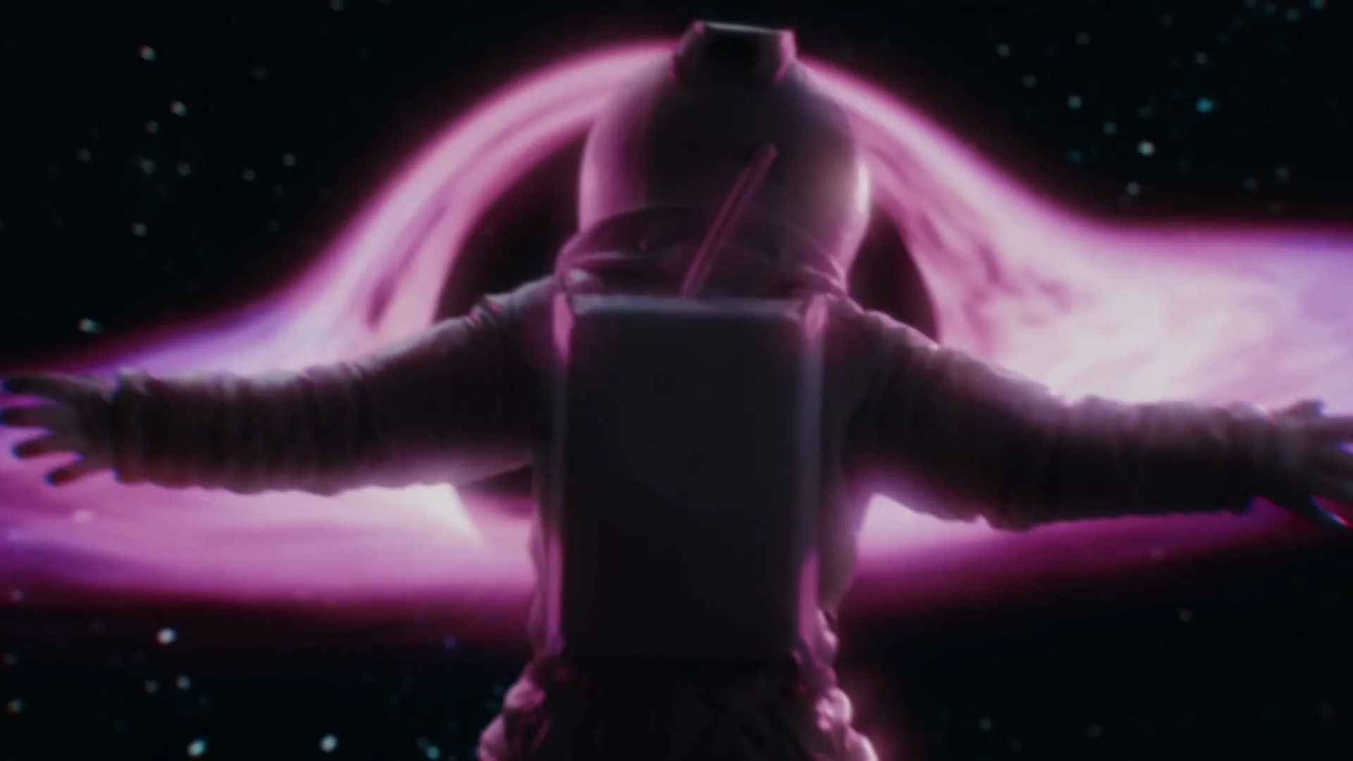 An astronaut in a white spacesuit floats with arms outstretched, facing away from the camera, against a backdrop of a swirling purple and black galaxy.