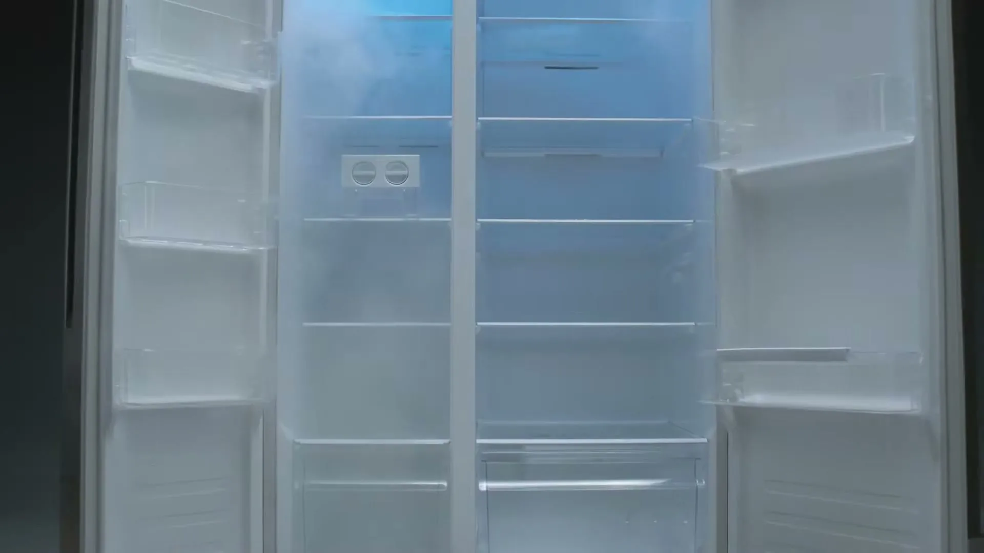 The doors of a modern, empty refrigerator open to reveal a cool, misty interior with blue light.