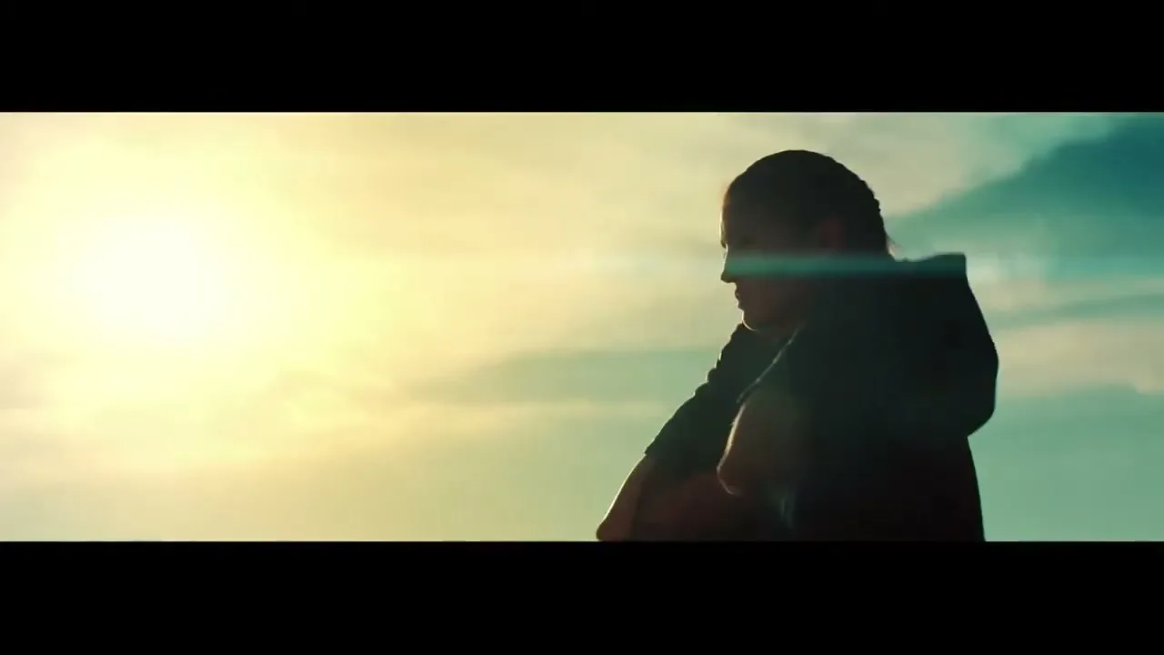 A young woman in silhouette practices martial arts against a bright sky with lens flare.