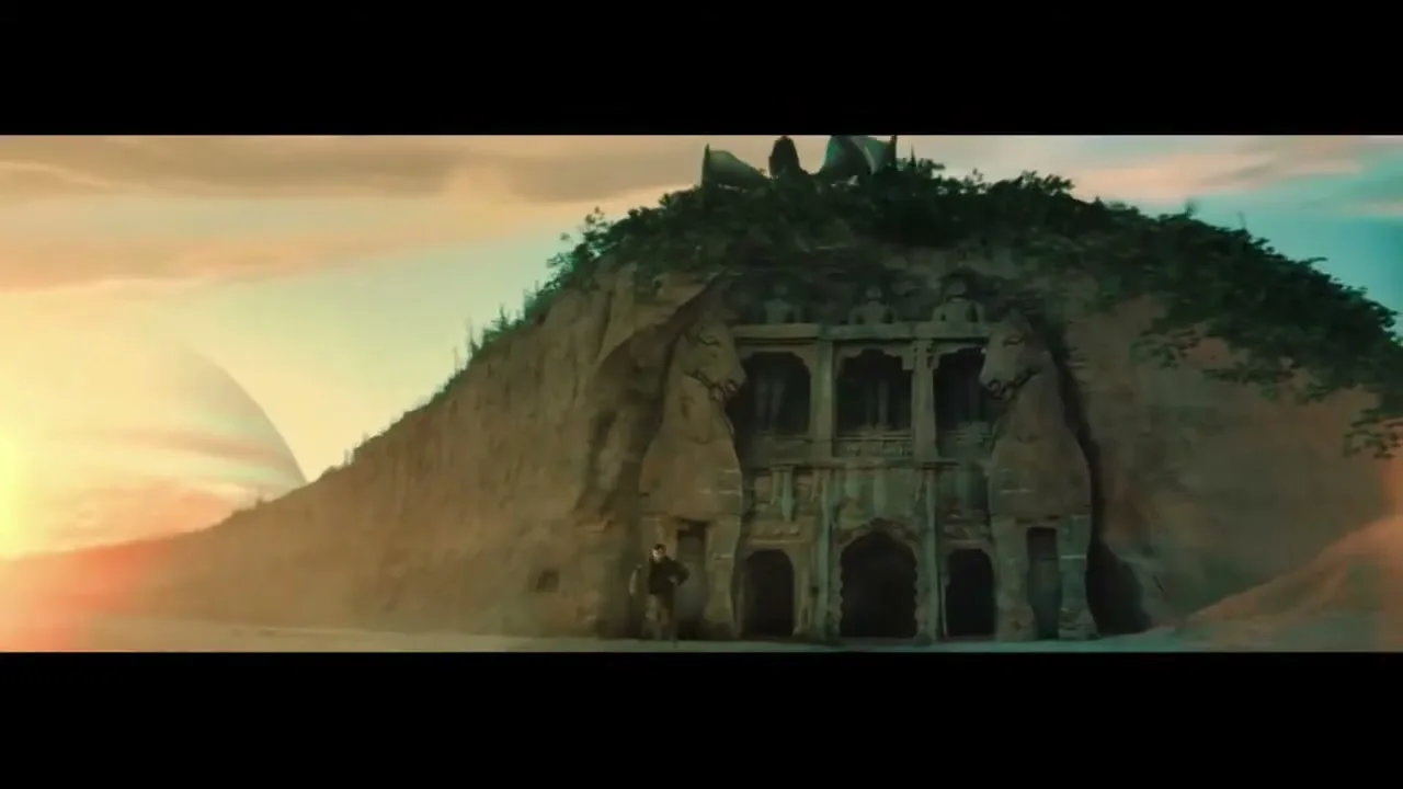 A lone male figure stands before an ancient, overgrown temple carved into a cliff face on an alien planet at sunset.